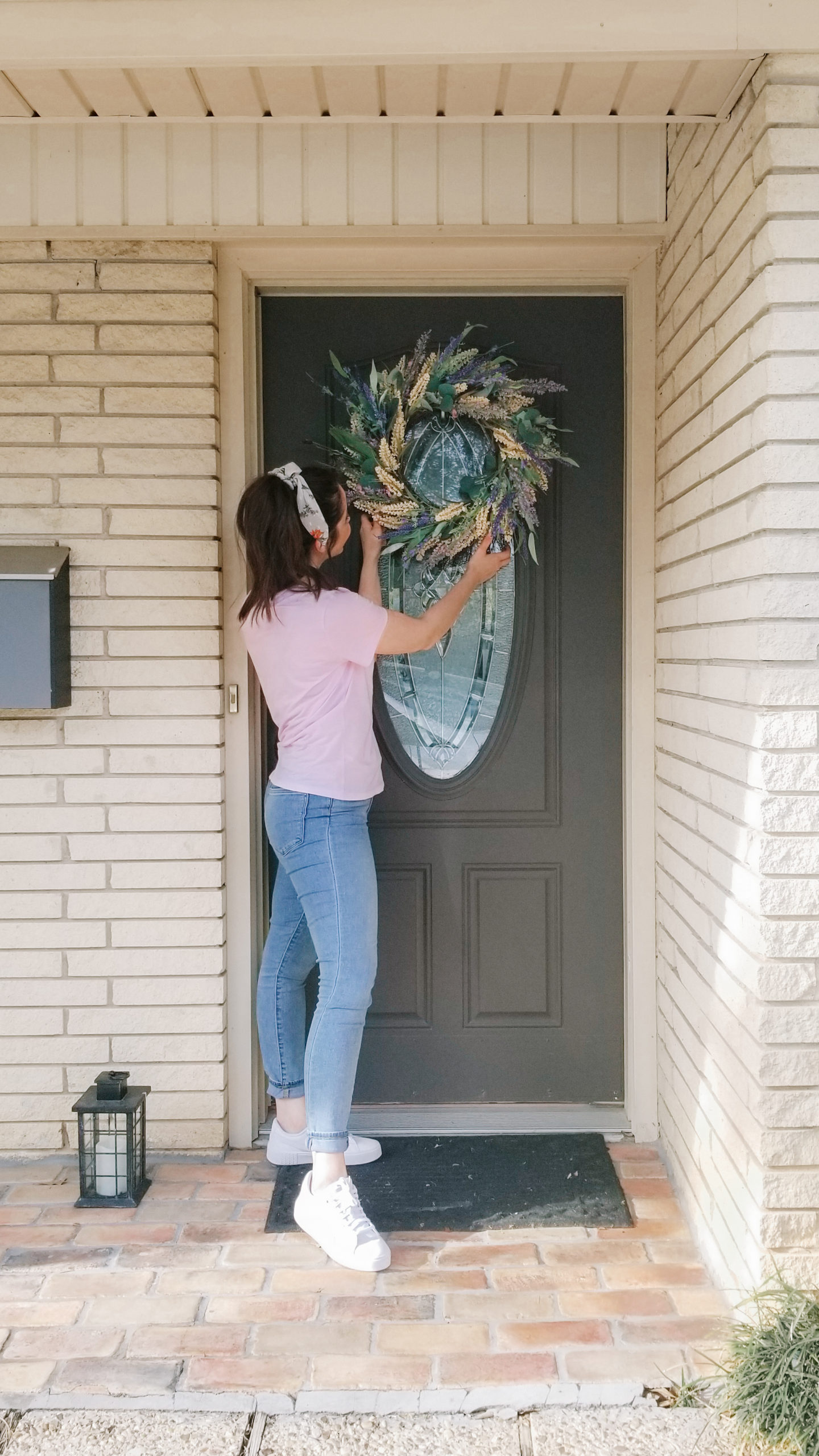 Placing my spring wreath on the front door